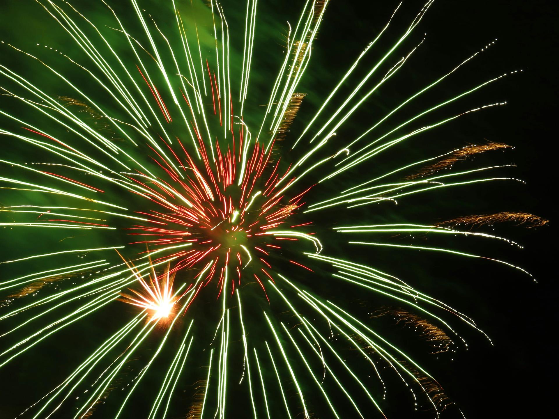 Fyrverkeri på himmelen i grønt og orange