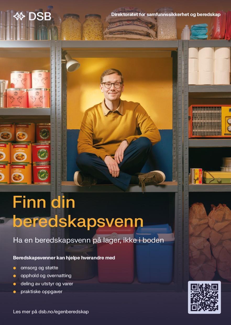 En mann som sitter i boden sammen med et lager av mat, fyrstikker, ved, toalettpapir og forskjellig boksemat - Klikk for stort bilde